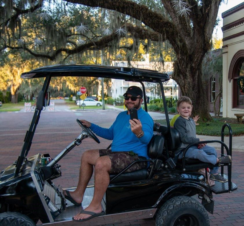 A family riding on a golf cart
