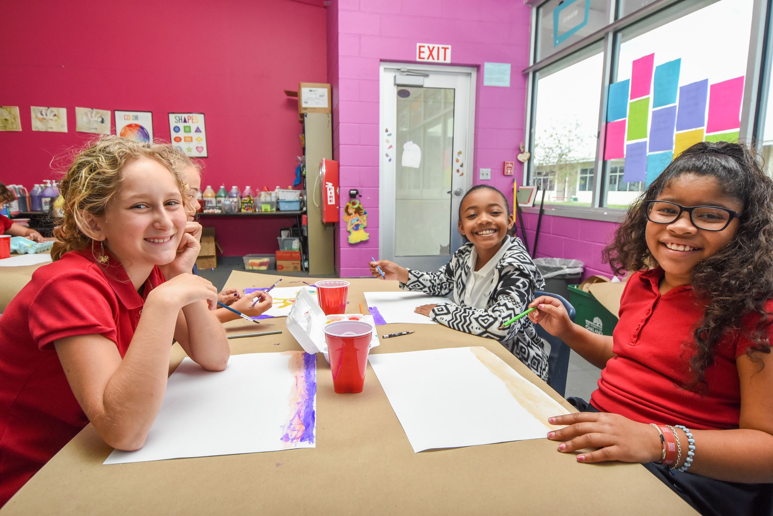 A group of girls painting in the Art classroom. 