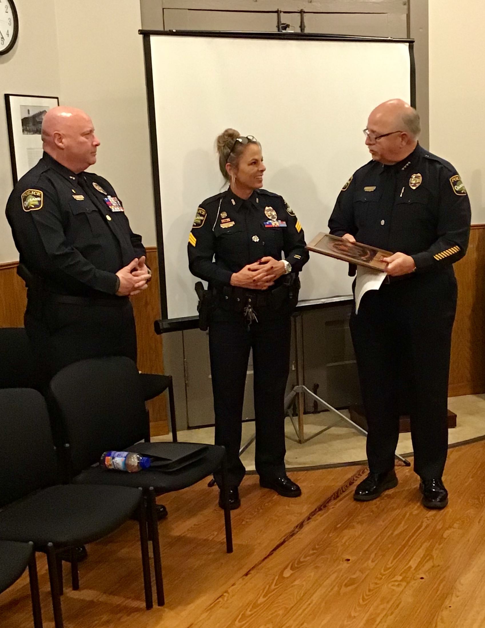 Chief Thomas presents plaque to Sergeant Campbell while Deputy Chief Peek looks on