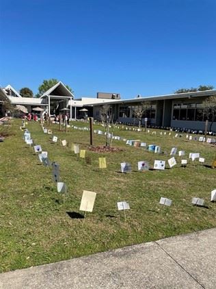 A view for the corner of the courtyard. Several pieces of artwork on stakes in the ground. 
